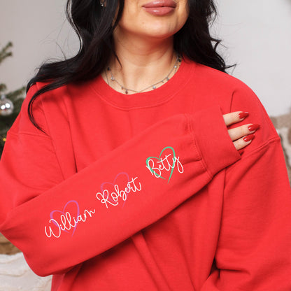 May include: Red sweatshirt with a long sleeve featuring the names "William Robert" and "Betty" written in cursive with hearts around them.