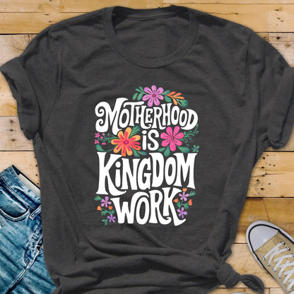 May include: A dark gray t-shirt with a white graphic that says "Motherhood is Kingdom Work" surrounded by colorful flowers.