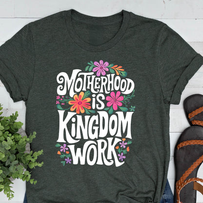 May include: A dark green t-shirt with a white graphic that says "Motherhood is Kingdom Work" surrounded by colorful flowers.