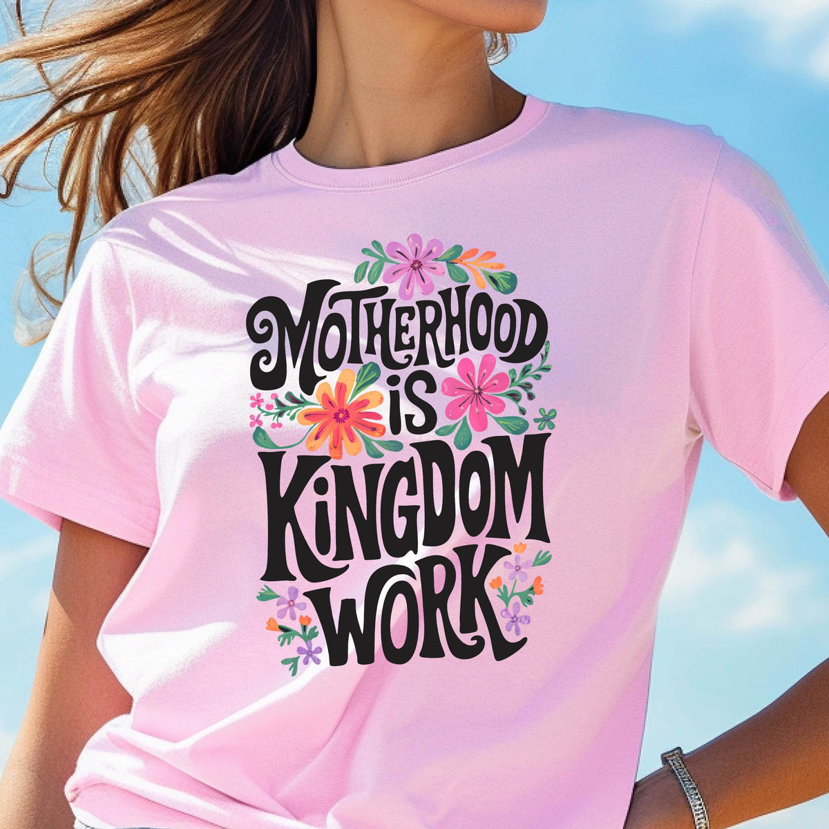 May include: Pink t-shirt with a floral design and the text "Motherhood is Kingdom Work" in black.