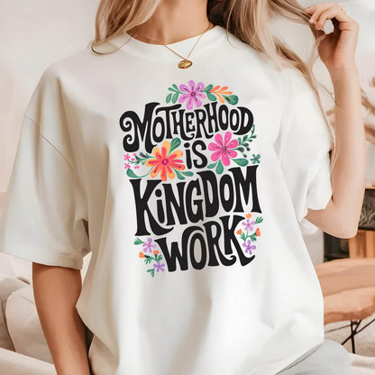 May include: White t-shirt with a floral design and the text "Motherhood is Kingdom Work" in black lettering.