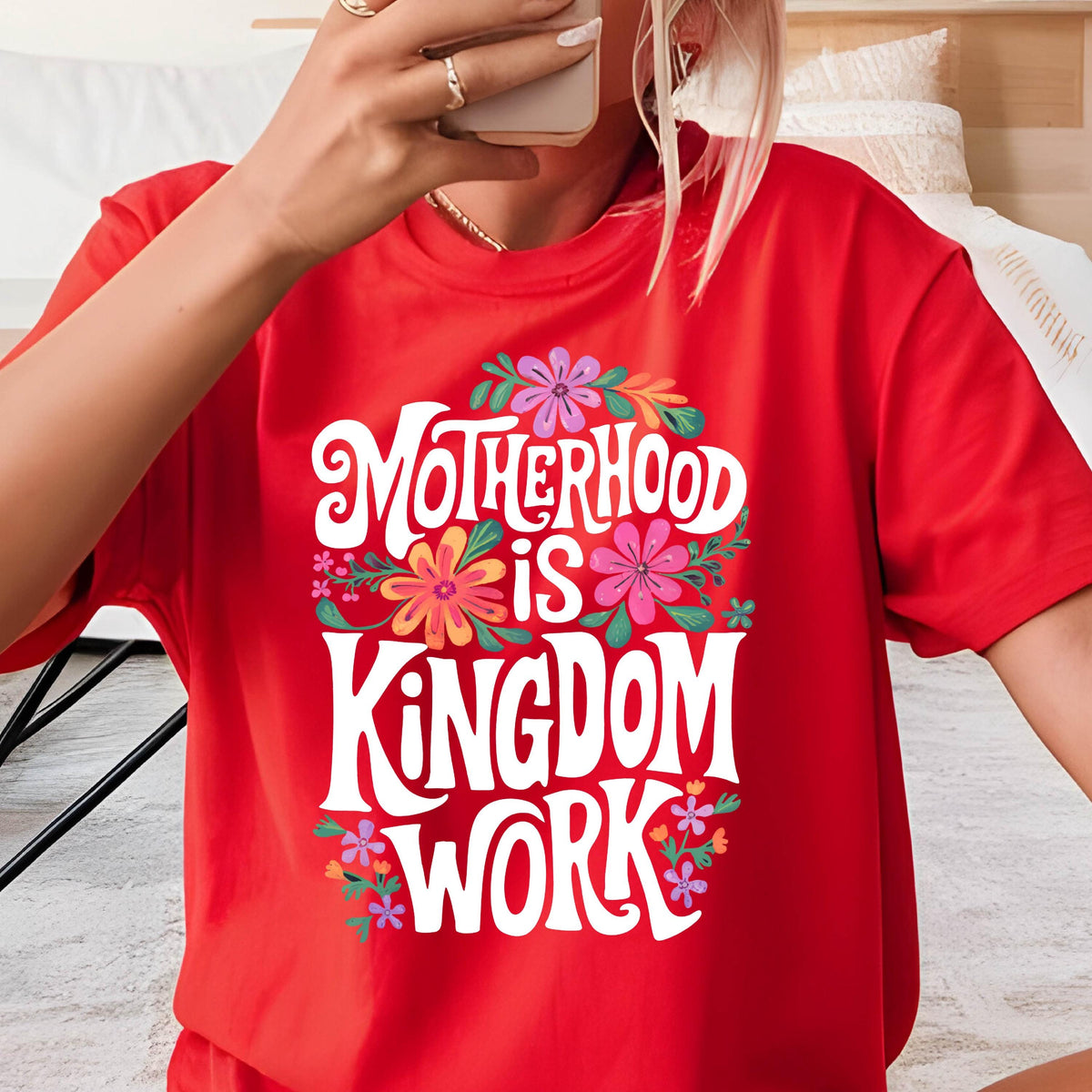 May include: Red t-shirt with a white graphic that says "Motherhood is Kingdom Work" surrounded by colorful flowers.