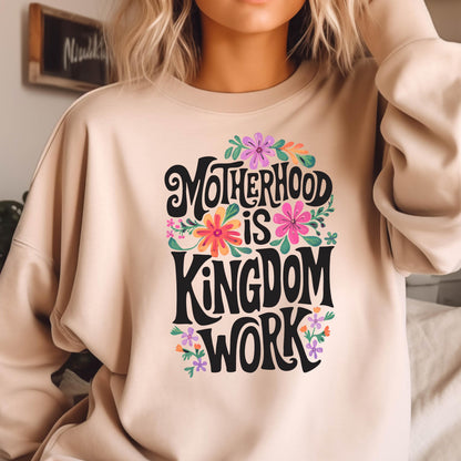 May include: A beige sweatshirt with a floral design and the text "Motherhood is Kingdom Work" in black lettering.