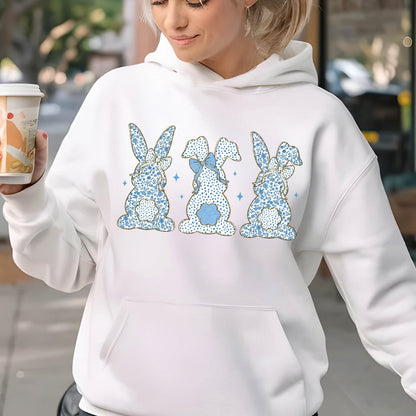 May include: White hoodie with a blue and gold bunny rabbit design. The bunnies are in a row and have bows on their heads.