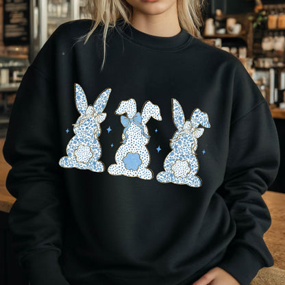 May include: Black sweatshirt with a graphic of three blue bunnies with white polka dots and blue bows. The bunnies are facing away from the viewer.