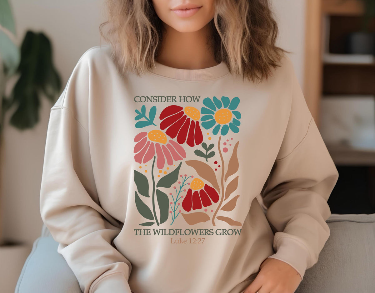 May include: A beige sweatshirt with a floral design and the text "Consider how the wildflowers grow Luke 12:27".