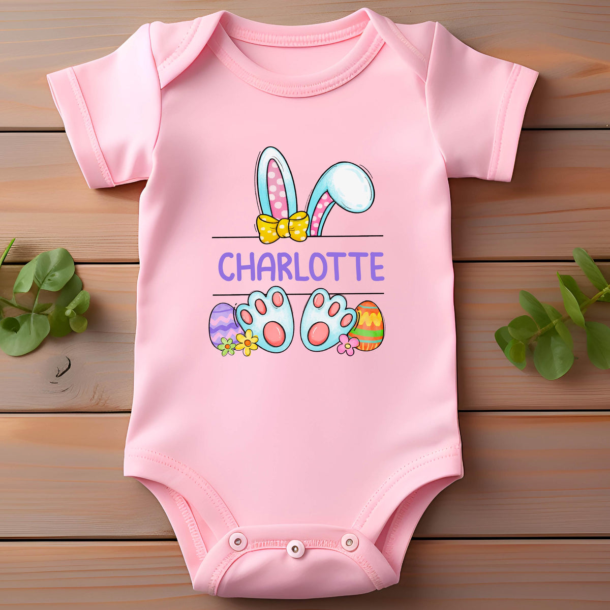 May include: Pink baby onesie with a cartoon bunny rabbit with Easter eggs and the name Charlotte.