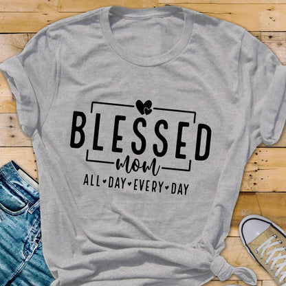 May include: Gray t-shirt with black text that reads "Blessed Mom All Day Every Day" with a heart symbol above the word "Blessed".