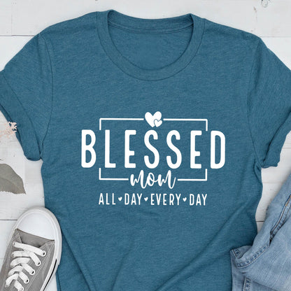 May include: Teal blue t-shirt with white text that reads "Blessed Mom All Day Every Day" with two white hearts above the word "Mom".
