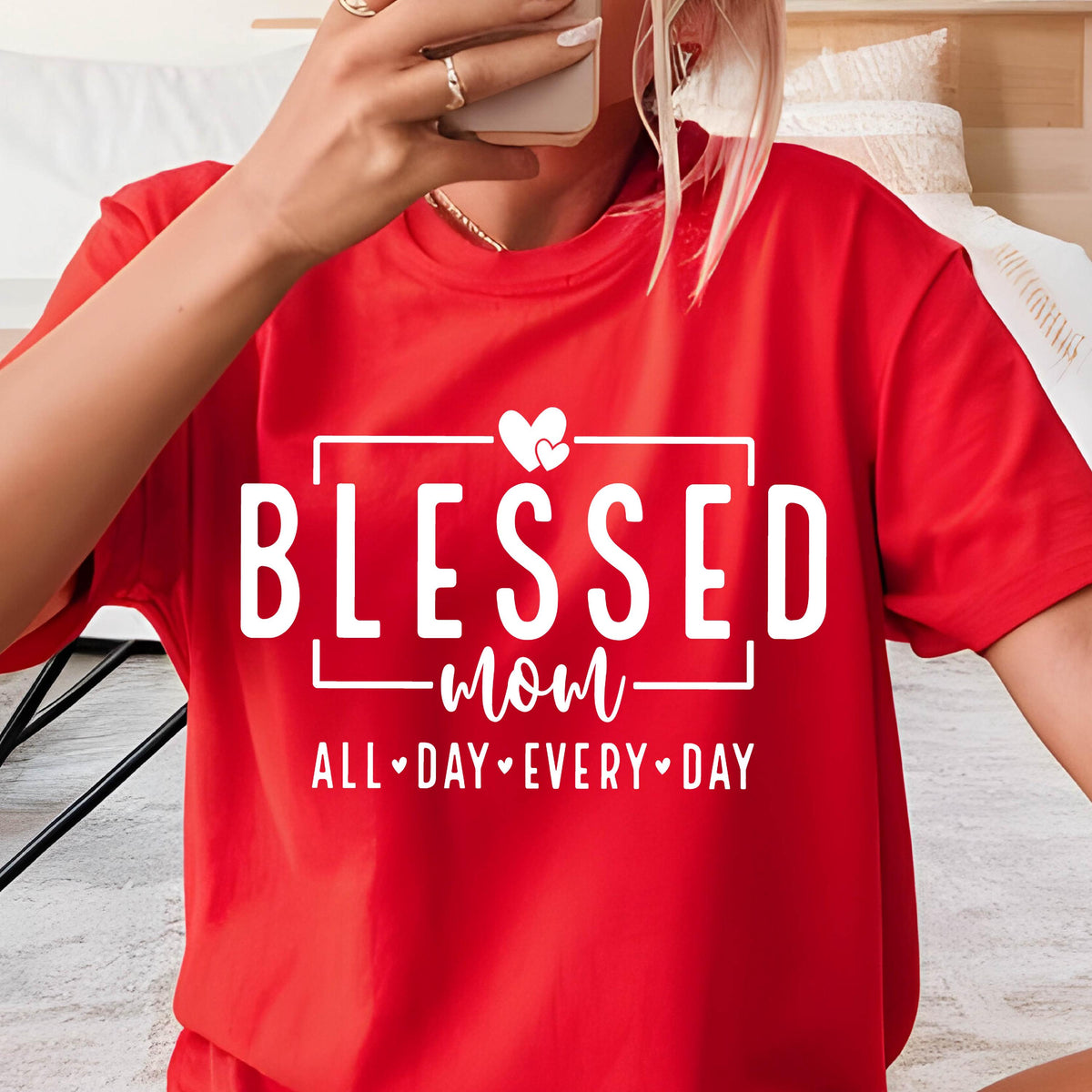 May include: Red t-shirt with white text that reads "Blessed mom all day every day" with two small hearts above the word "mom".