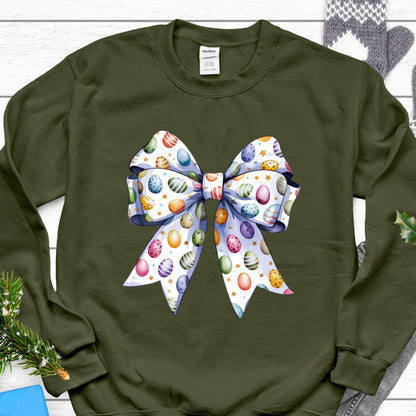 May include: A green sweatshirt with a white bow printed on the front. The bow is decorated with colorful Easter eggs.