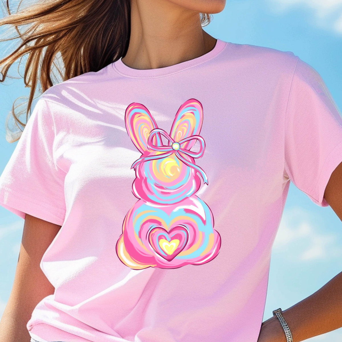 May include: Pink t-shirt with a colorful swirl design of an Easter bunny with a bow and a heart.