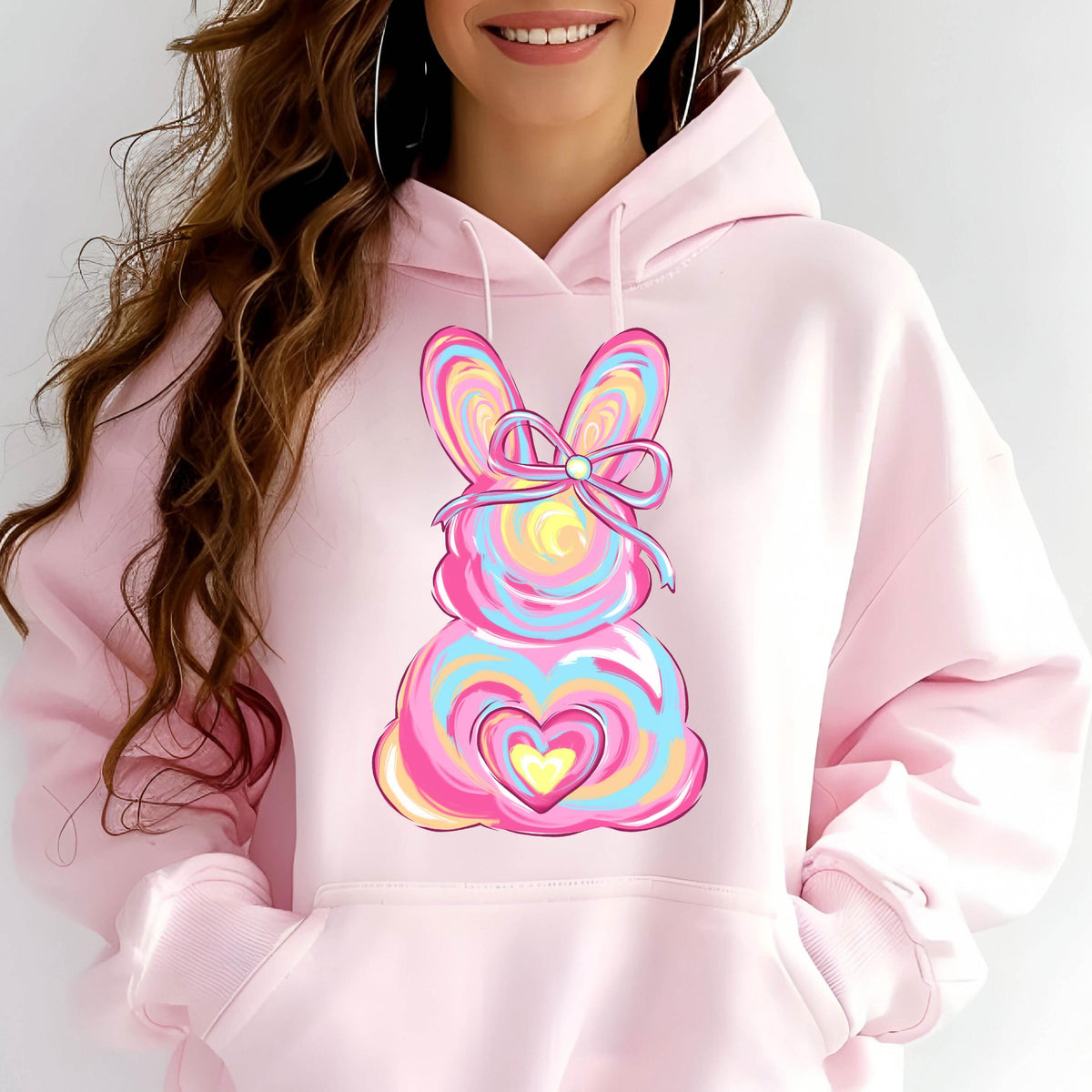May include: Pink hoodie with a colorful swirl design of a bunny with a bow and a heart on the front.
