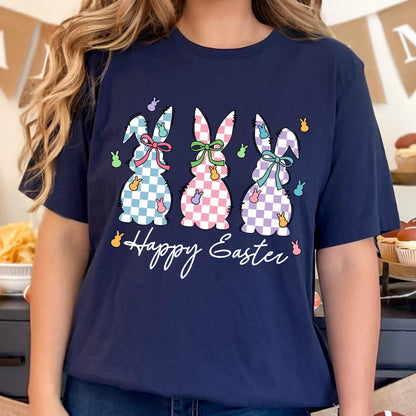May include: A navy blue t-shirt with a graphic of three checkered Easter bunnies in pink, purple, and blue. The bunnies are holding pastel-colored jelly beans. The text "Happy Easter" is written below the bunnies.