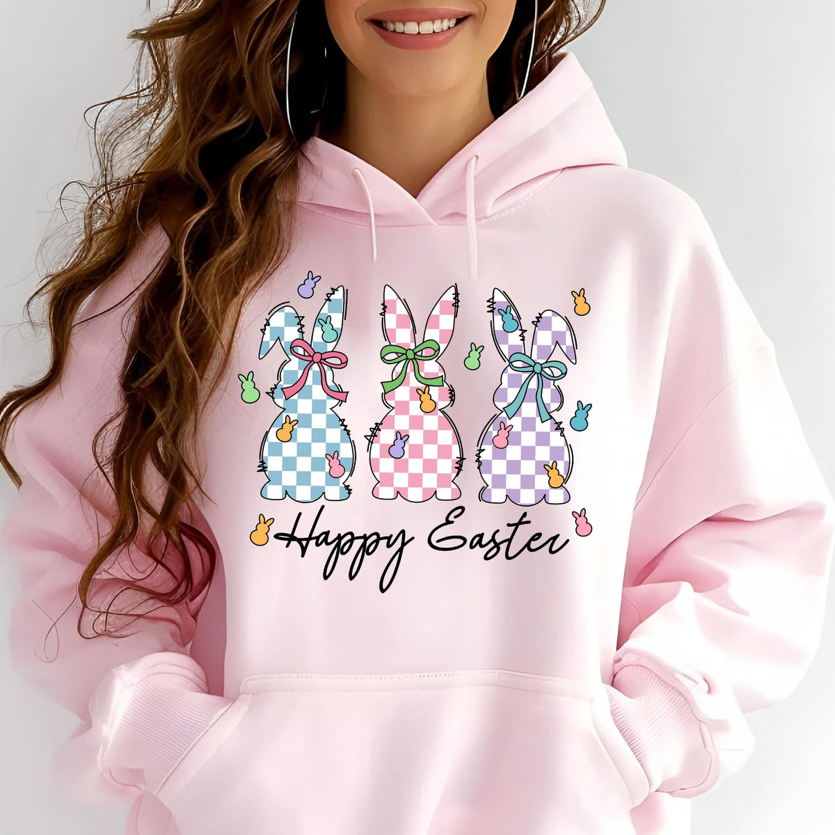 May include: A pink hoodie with a graphic of three checkered Easter bunnies and the text "Happy Easter".
