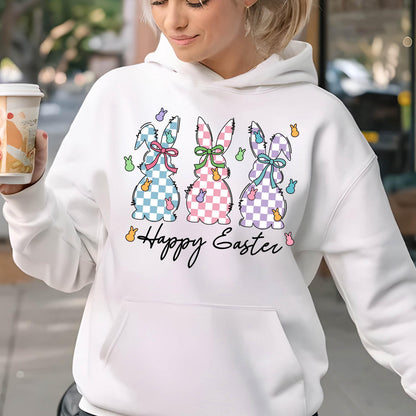 May include: White hoodie with a graphic of three pastel colored bunnies with checkered patterns and bows. The bunnies are surrounded by small pastel colored eggs. The text "Happy Easter" is printed below the bunnies.