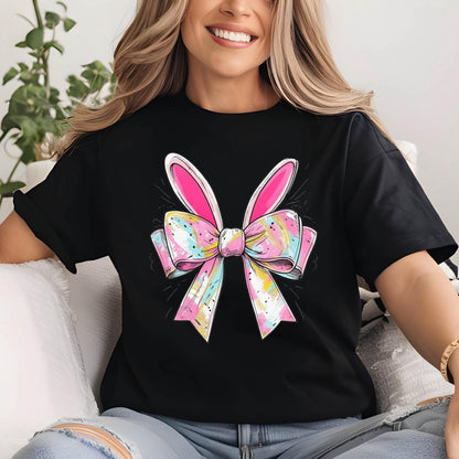 May include: Black t-shirt with a pink and white bow with bunny ears. The bow has a colorful, abstract pattern.