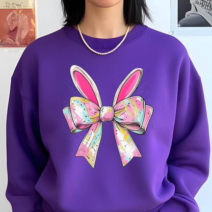 May include: Purple sweatshirt with a colorful bow and bunny ears design. The bow is pink, yellow, blue, and white with a white and gold glitter effect. 