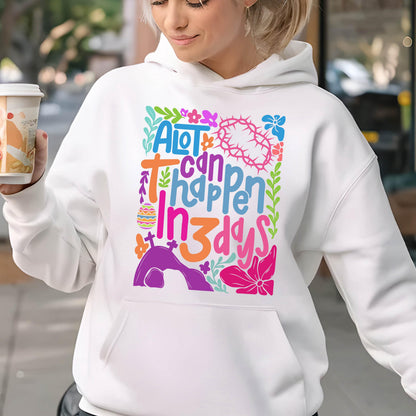 May include: White hoodie with a colorful graphic design that says "A lot can happen in 3 days". The graphic includes flowers, a cross, and an Easter egg.