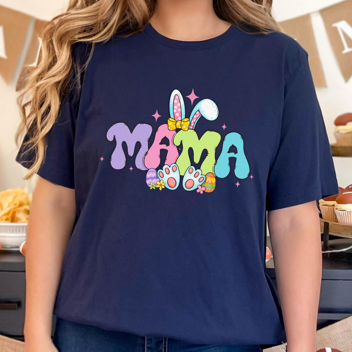 May include: A navy blue t-shirt with a colorful graphic of the word "MAMA" with bunny ears and Easter eggs. 
