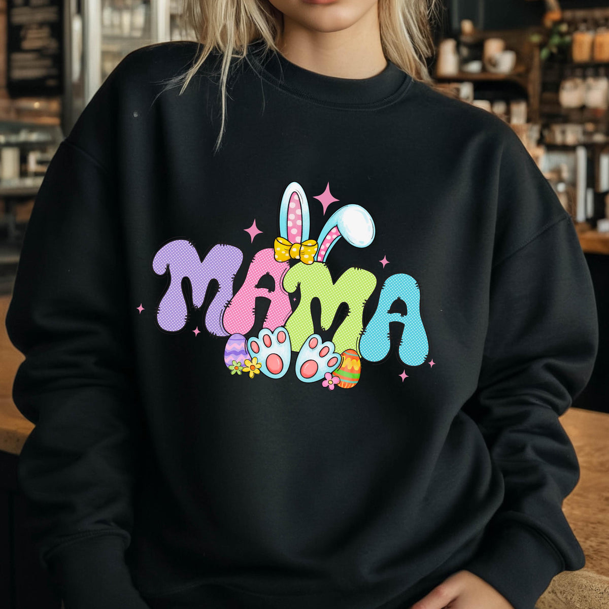 May include: Black sweatshirt with a colorful graphic of the word "MAMA" with bunny ears, a bow, and Easter eggs.