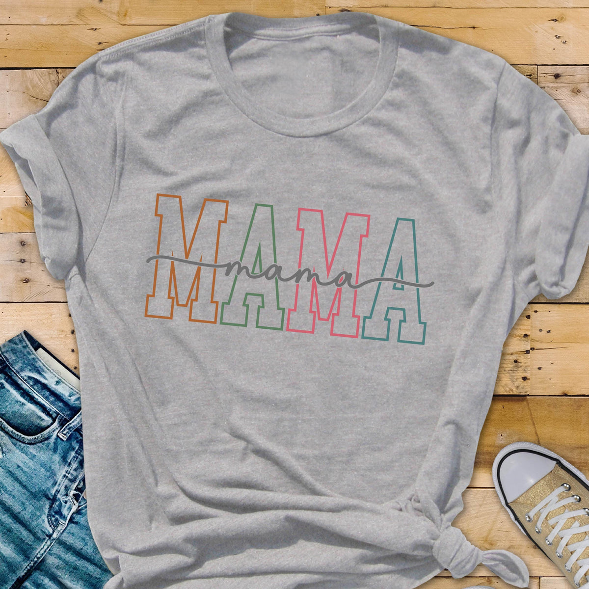 May include: Gray t-shirt with the word "MAMA" in colorful block letters and the word "mama" written in cursive underneath.