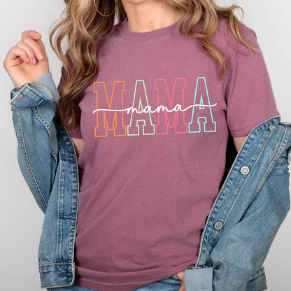 May include: A mauve colored t-shirt with the word "MAMA" in rainbow colored letters with a script font "mama" underneath.