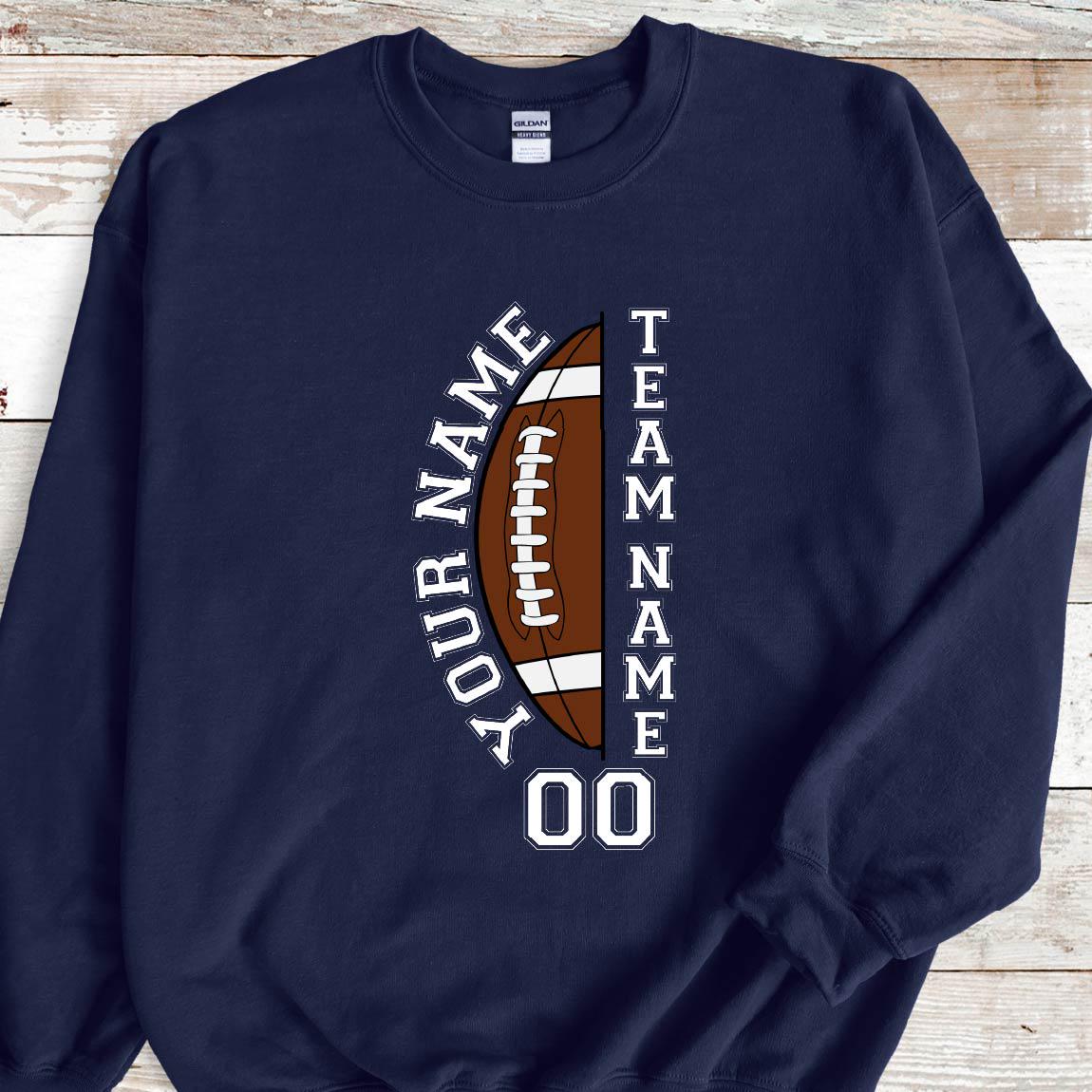 May include: Navy blue sweatshirt with a football graphic. The design includes the words "YOUR NAME" and "TEAM NAME" around a brown and white football, with the number "00" at the bottom. The sweatshirt is a Gildan brand.