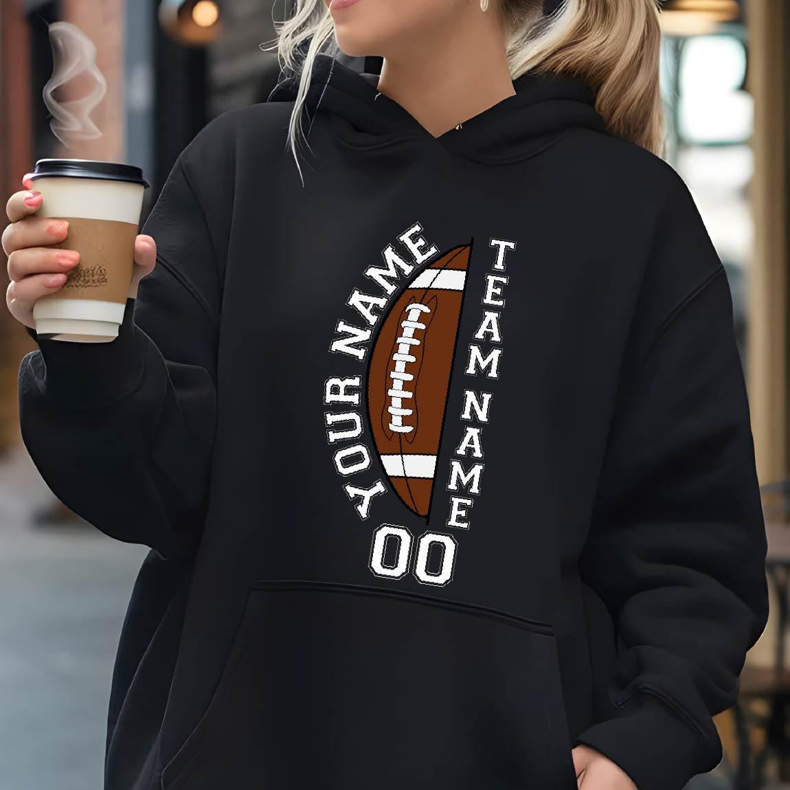 May include: Black hoodie with a football graphic. The design includes a brown football with white laces, the words "YOUR NAME" and "TEAM NAME" in white, and the number "00" in white.