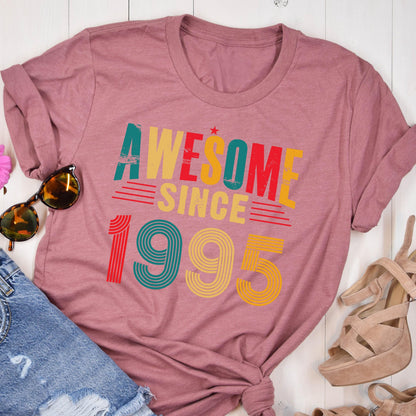 May include: A mauve t-shirt with a vintage-style graphic that reads "Awesome Since 1995". The graphic is in red, yellow, green, and blue.