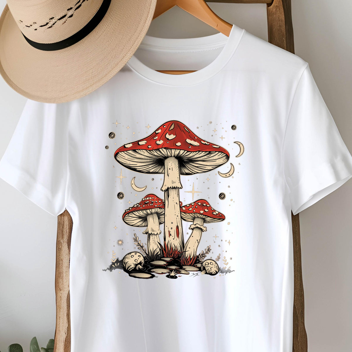 May include: White t-shirt with a graphic of three red and white mushrooms with a starry night background.
