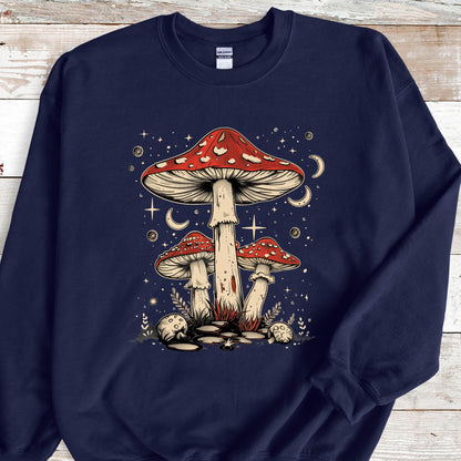 May include: Navy blue sweatshirt with a graphic of three red and white mushrooms with white spots. The mushrooms are surrounded by white stars and crescent moons. 