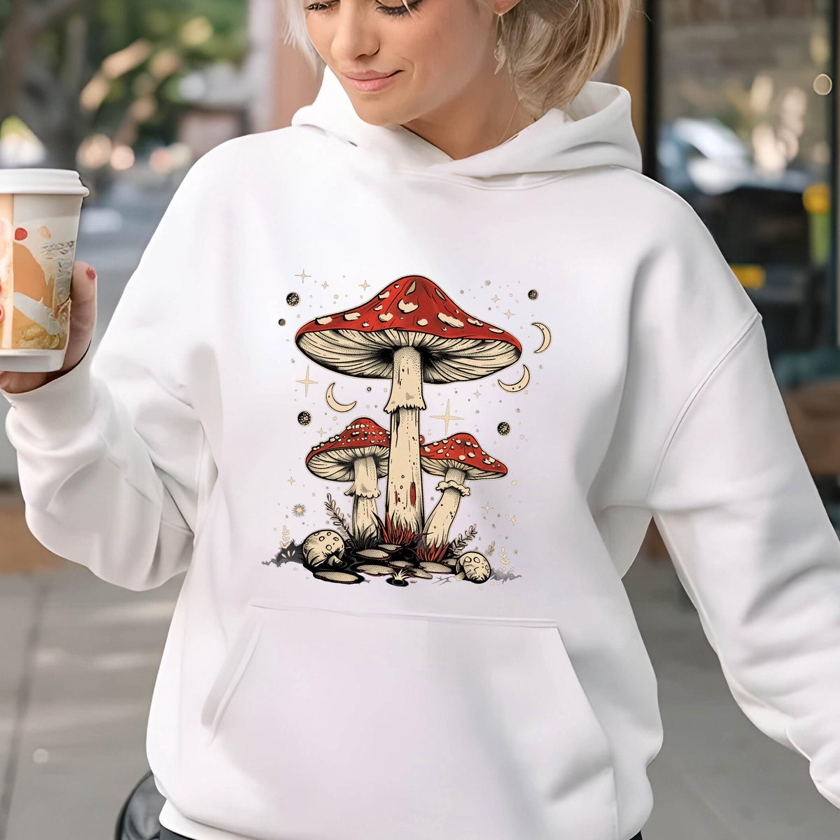 May include: White hoodie with a graphic of three red and white mushrooms with white stems against a background of white stars and crescent moons.