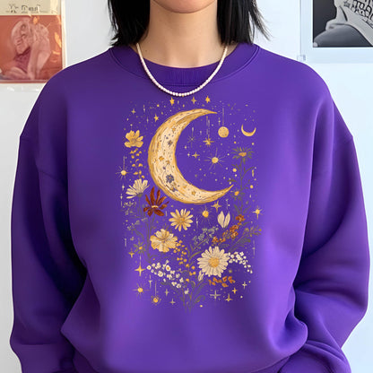 May include: A vibrant purple crewneck sweatshirt featuring a central graphic print of a large golden crescent moon surrounded by various yellow and white wildflowers, small stars, and celestial sparkles scattered across the front of the garment.