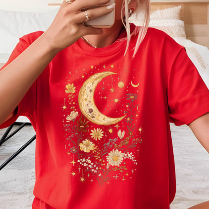 May include: Red t-shirt with a crescent moon and floral design in yellow, white, and brown. The design is surrounded by small stars.