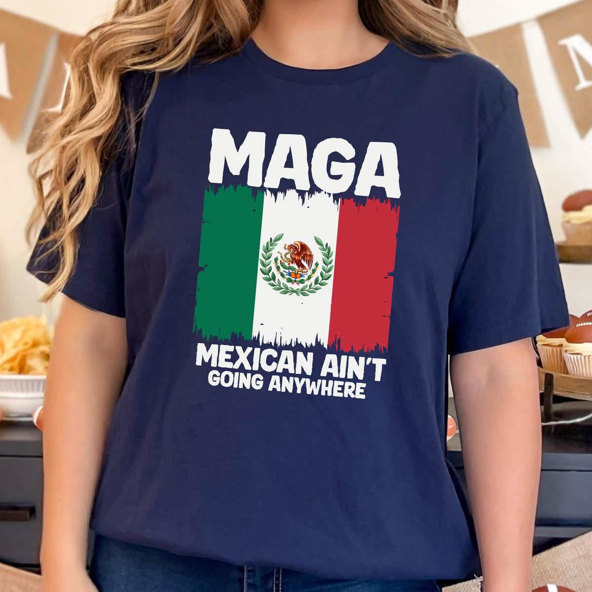 May include: A navy blue t-shirt with a white graphic of the Mexican flag and the text "Maga Mexican Ain't Going Anywhere".