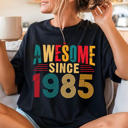 May include: Black t-shirt with a vintage-style graphic that says "Awesome Since 1985" in colorful, striped lettering.