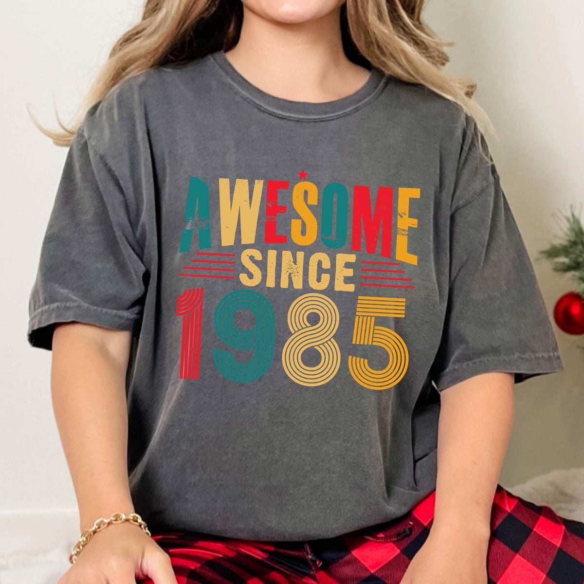 May include: A gray t-shirt with a vintage-style graphic that says "Awesome Since 1985" in colorful lettering.
