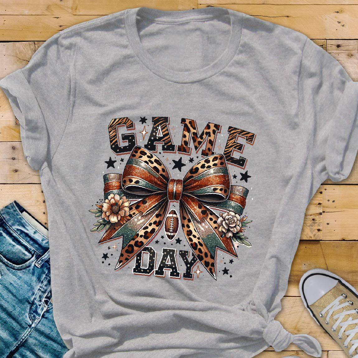 May include: Gray t-shirt with a leopard print bow and the text "GAME DAY" in black letters.