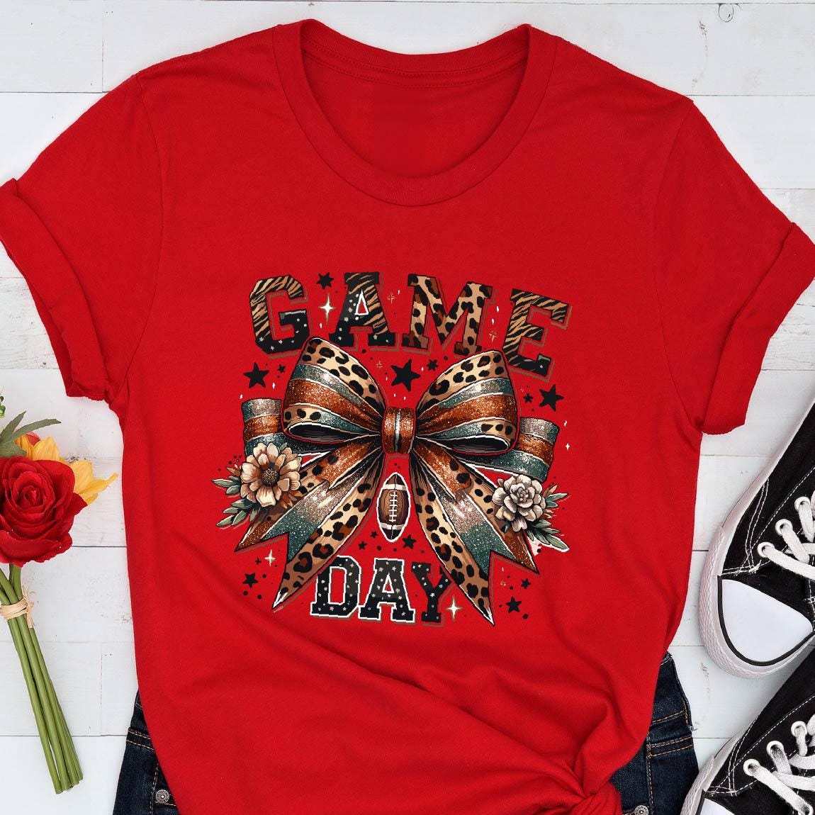May include: Red t-shirt with a leopard print bow and the words "GAME DAY" in black lettering.