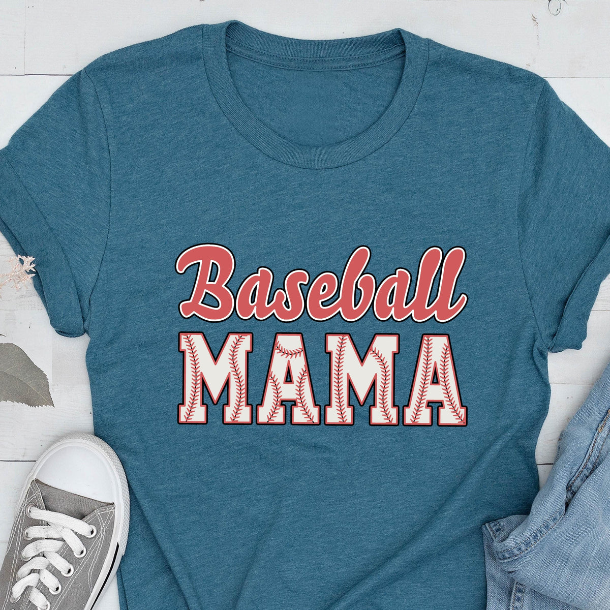 May include: A teal blue t-shirt with the text "Baseball Mama" in red and white. The word "Mama" is surrounded by a white baseball stitch design.