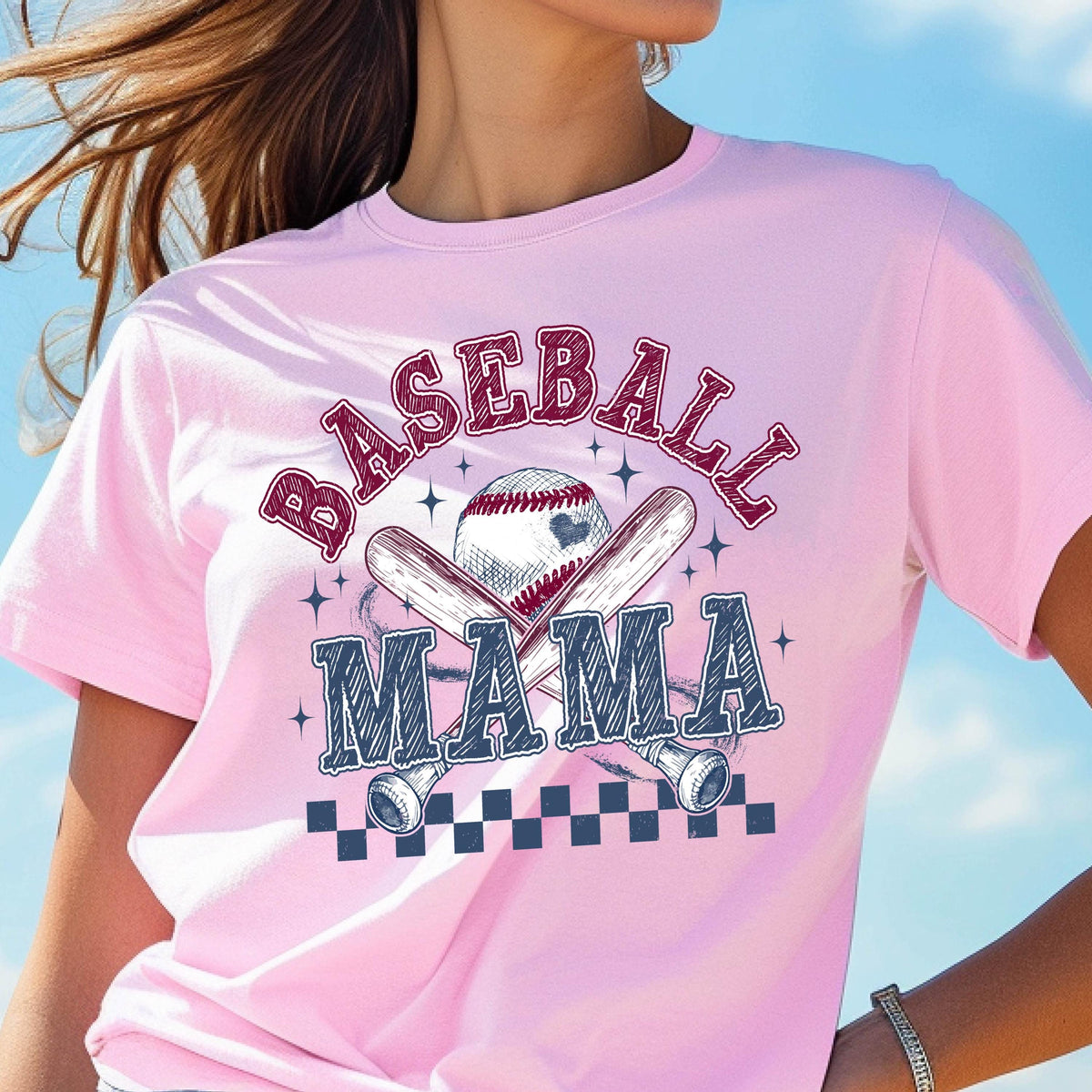 May include: Pink t-shirt with a baseball graphic and the text "Baseball Mama" in a white and blue checkered pattern.