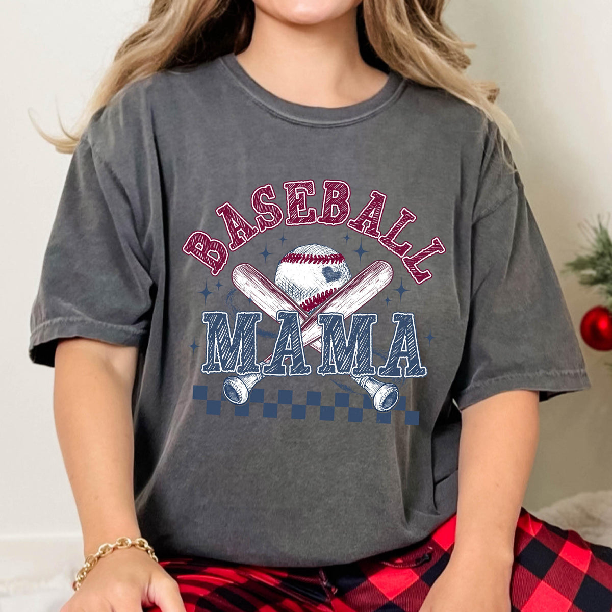 May include: A gray t-shirt with the text "BASEBALL MAMA" in red and blue lettering. A baseball and crossed bats are depicted in the center of the shirt.