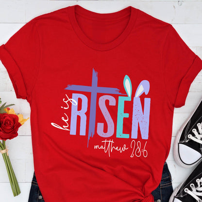 May include: Red t-shirt with a purple, blue, and teal graphic that says "He is Risen" with a cross and bunny ears. The text "matthew 28:6" is below the graphic.