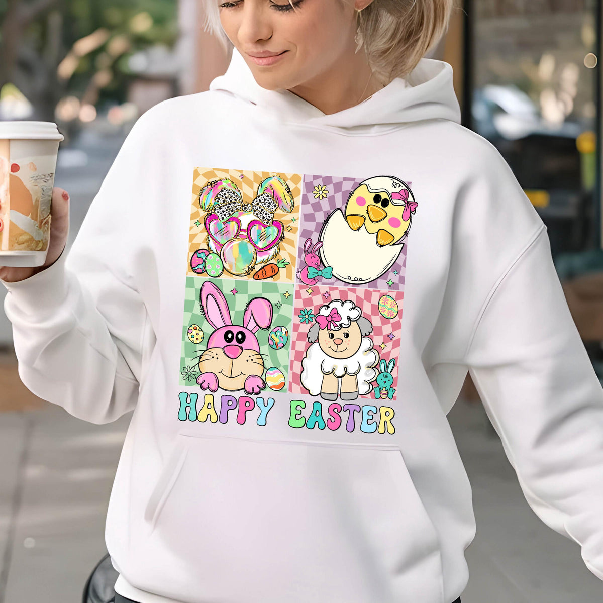 May include: White hoodie with a colorful graphic of Easter animals and eggs. The graphic includes a bunny, a chick, a lamb, and eggs. The text "Happy Easter" is printed below the graphic.