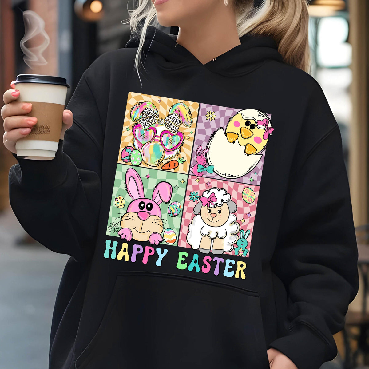 May include: Black hoodie with a colorful graphic of four Easter animals. The animals are a bunny, a chick, a lamb, and a bunny wearing sunglasses. The text "Happy Easter" is printed below the graphic.