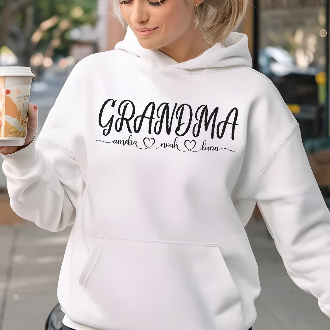 May include: White hooded sweatshirt with the text "Grandma" and the names "Amelia", "Noah", and "Luna" written below in a cursive font.