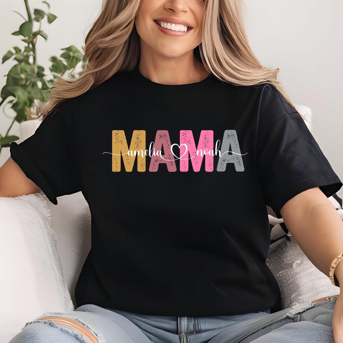 May include: Black t-shirt with the word "MAMA" in colorful letters with a heart and the names "Amelia" and "Noah" underneath.