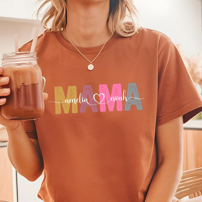 May include: A brown t-shirt with the word "MAMA" in colorful letters. The letters are decorated with a heart and the names "Amelia" and "Noah" written in cursive.