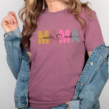 May include: A mauve t-shirt with the word "MAMA" in colorful block letters. The letters are decorated with the names "Amelia" and "Noah" and a heart.